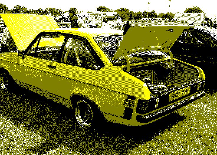 Image converted by 'CPiC'. A yellow vintage car with its hood open, parked in a grassy field at a car show. Other cars and people in the background.